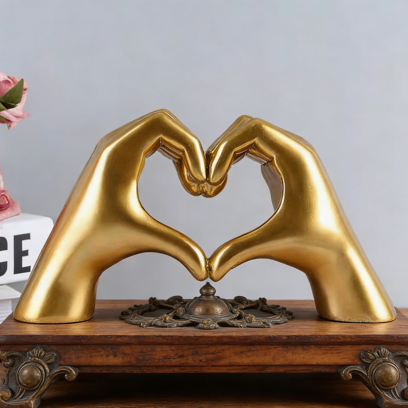 Gouden hand in de vorm van een hartje, gemaakt van hars.